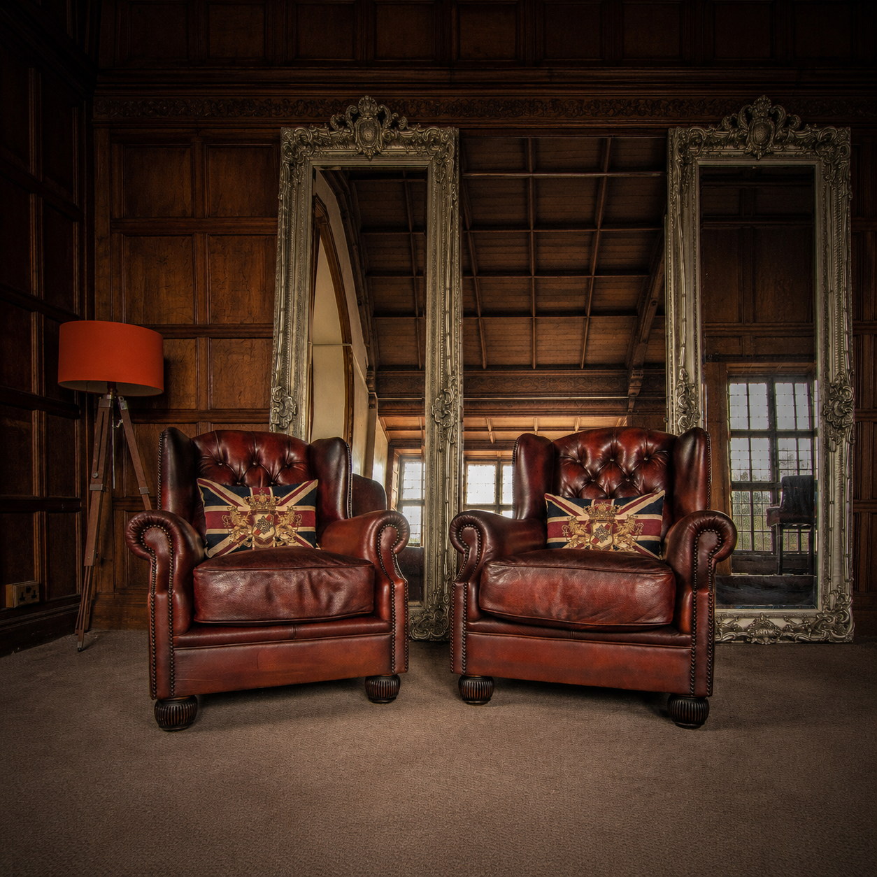 Two restored leather wingback armchairs with Union Jack cushions